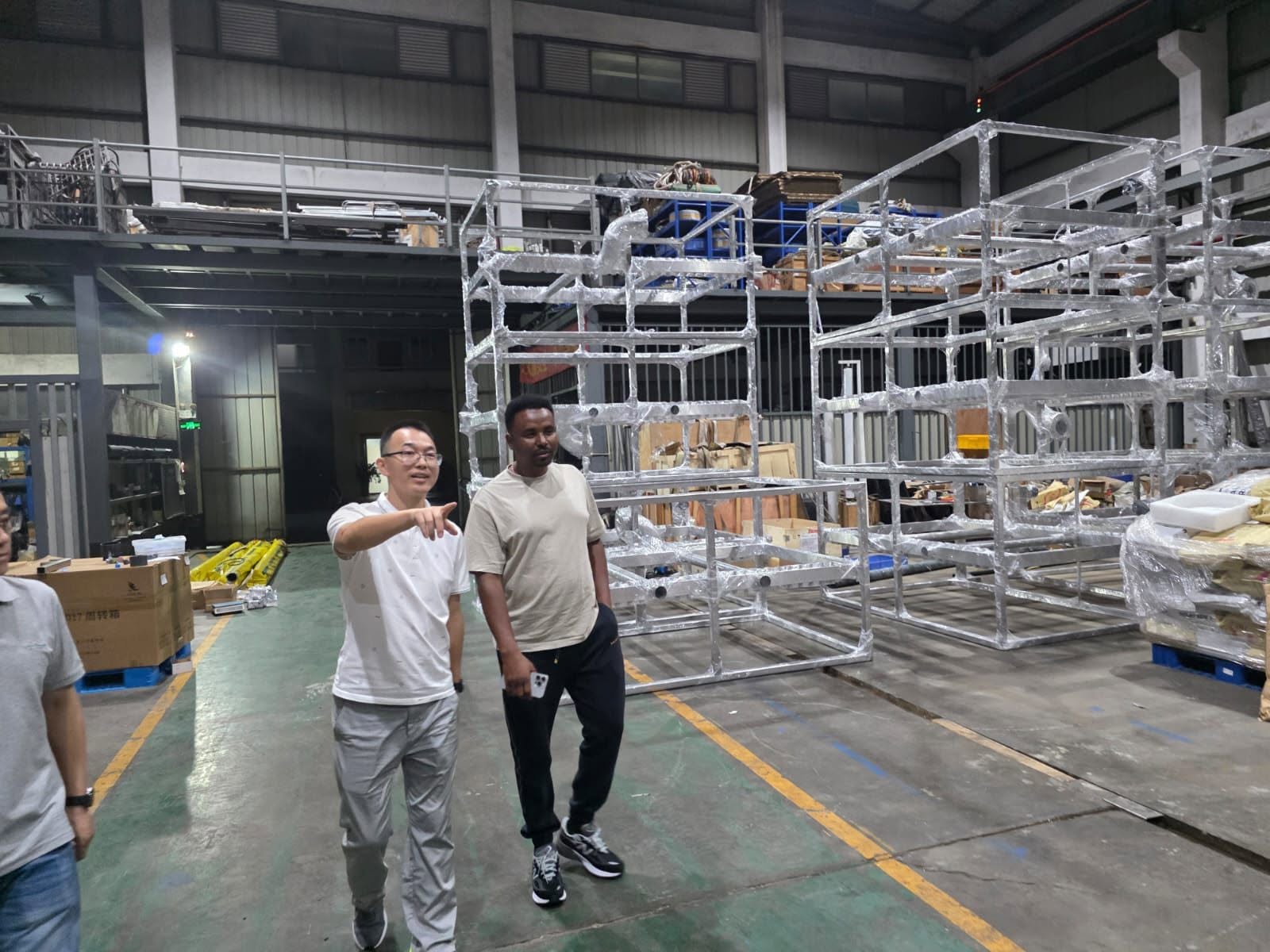 来访人员与华清代表在水处理设备框架旁参观交流